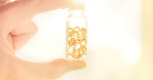 A hand holding a bottle of Vitamin D3 and K2