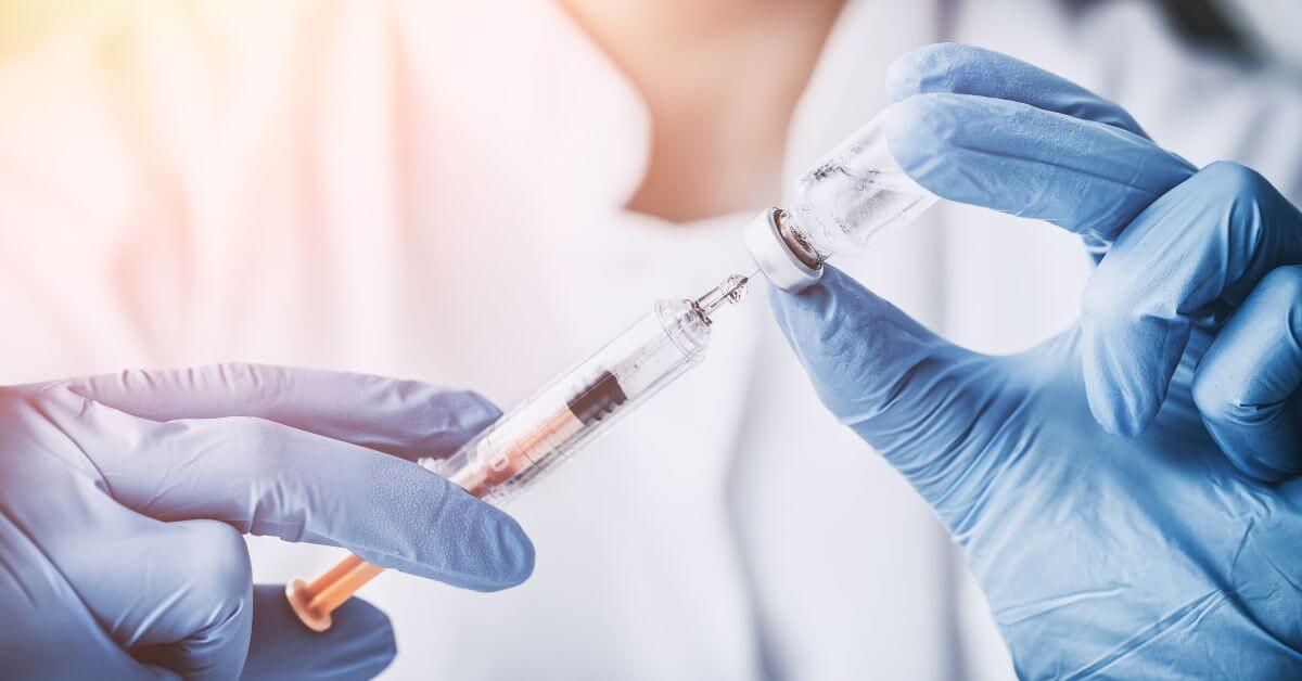 A doctor with a syringe and vial of peptide therapy.