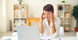 Woman at her computer experiencing post-viral fatigue