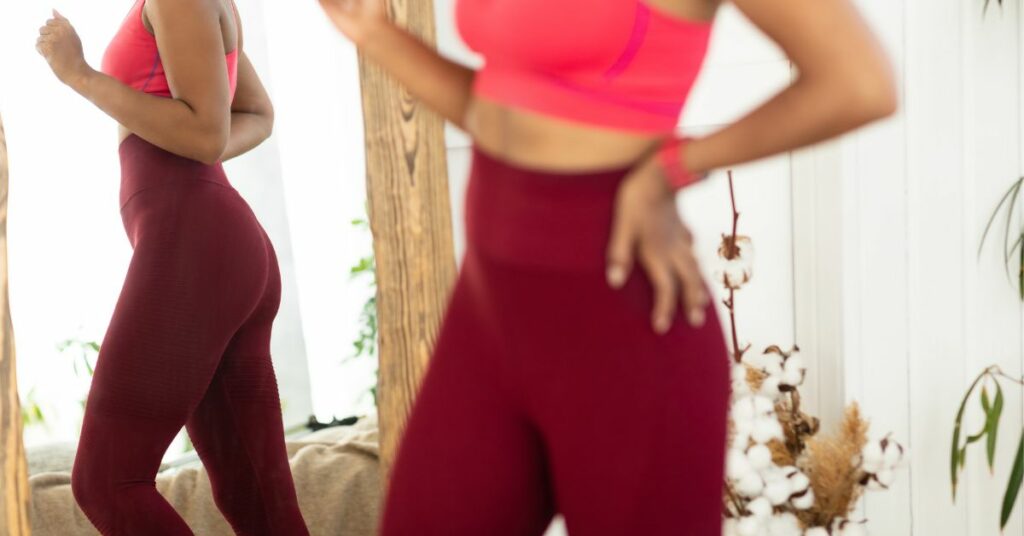 Woman looking in the mirror at her sustained weight loss from Ozempic 