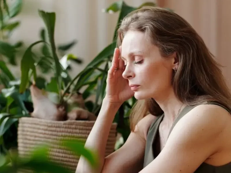Thyroid-issues-600×800 Woman with thyroid issues with her hand to her head and eyes closed.
